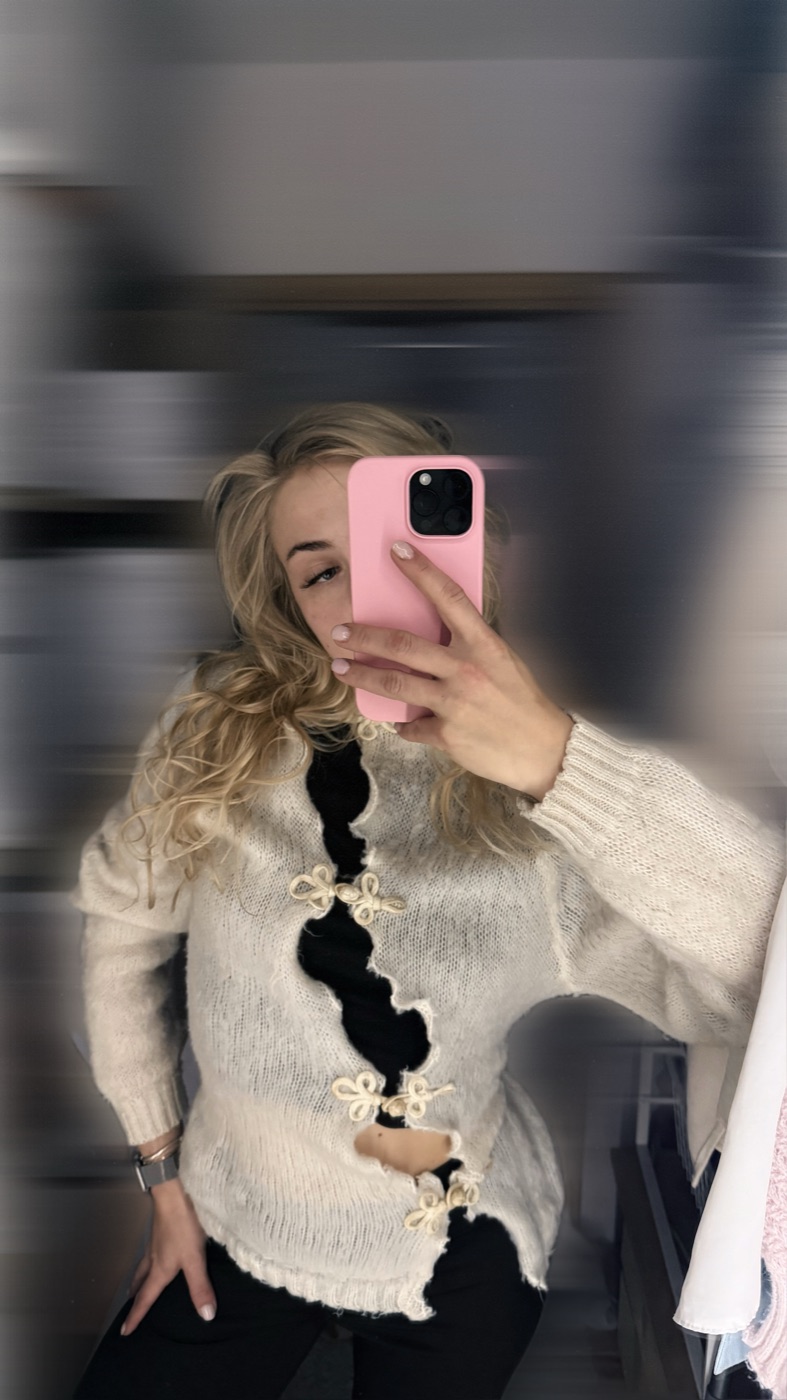Cream knit sweater with a cut-out front held by small bows