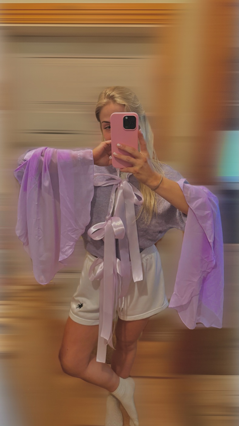 Sheer lilac top with bell sleeves and a large bow